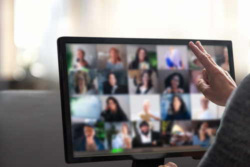 Eine Person sitzt vor einem Laptop und hält ein Online-Meeting ab.