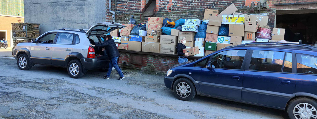 Zwei Autos vor Kartons mit Hilfsgütern