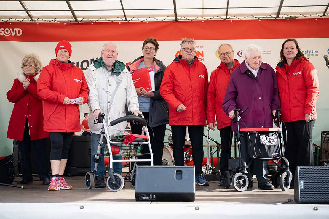 Sieben Personen auf einer Bühne. 