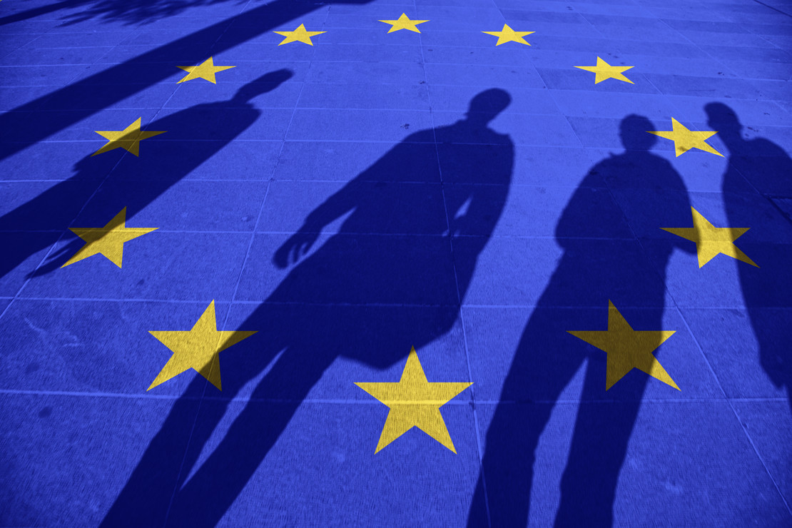 Schatten von Menschen auf gelben EU-Sternen