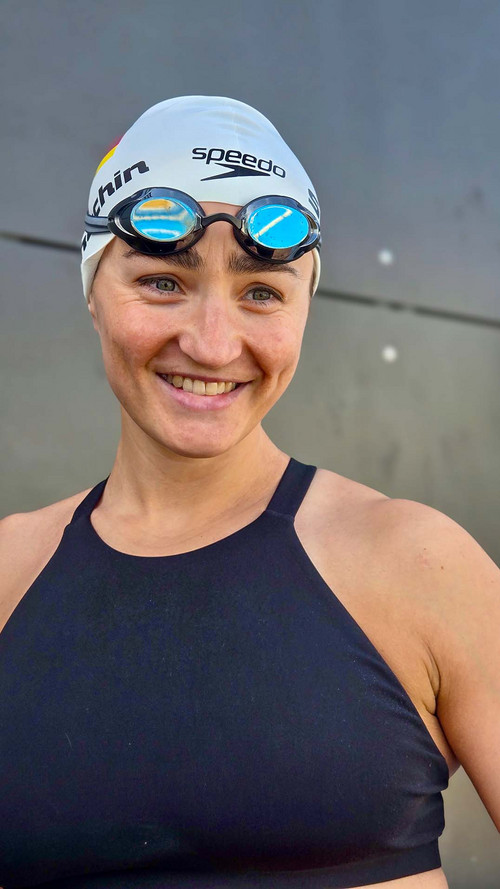 Elena Semechin in Badekleidung mit Schwimmbrille und Badekappe. 