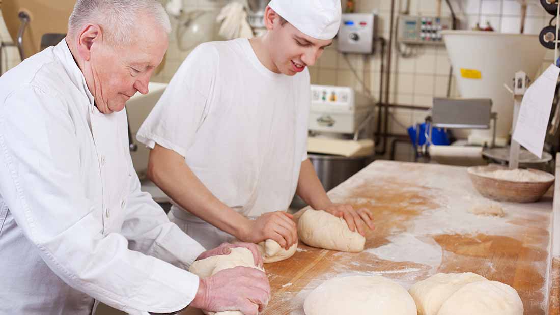 Alter und junger Mann arbeiten in Bäckerei. 