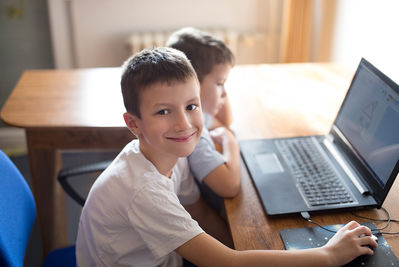 Kinder vor einem gebrauchten Laptop